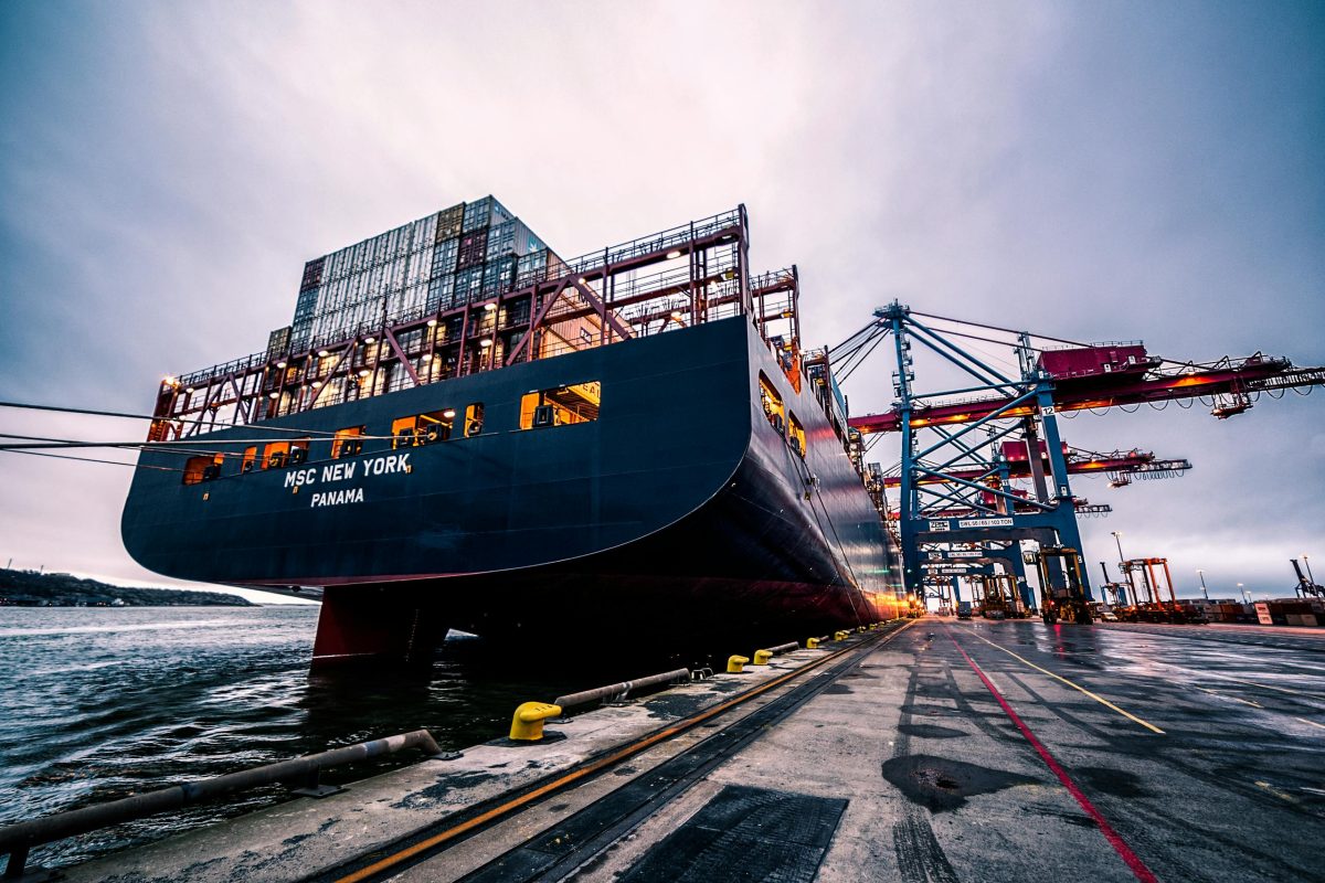 A large cargo ship docked at Gothenburg port with industrial cranes, Sweden.